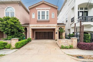 A two-story house with a garage, stone foundation, and a well-maintained front yard. - Houston Centrally Located w/ Backyard Pool Retreat (Houston)