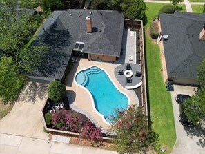 An aerial view of a residential property with a swimming pool, a covered patio, and a well-maintained lawn. - Allen Abode - 4 Bedrm. Pool, Fire Pit , Charm (Allen)