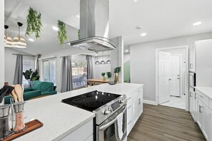 A modern kitchen with a central island, built-in oven, and stainless steel appliances. - Best of Desoto, 5br, 2BA With Pool, Hot Tub, Patio (DeSoto)