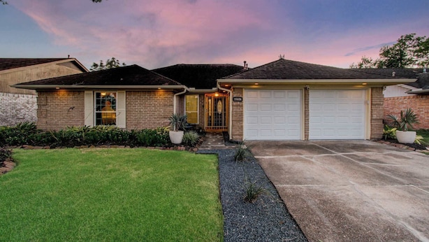 A two-story house with a garage, a well-maintained lawn, and a driveway. - Your Houston Vacation Getaway, 4-bd, Pool, Patio (Houston)
