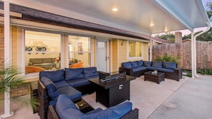 An outdoor patio with a sectional sofa, a coffee table, and a fire pit. - Your Houston Vacation Getaway, 4-bd, Pool, Patio (Houston)