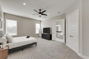 A bedroom with a bed, a dresser, a TV, and a ceiling fan. - Modern and Spacious High End Home Near Downtown (Dallas)