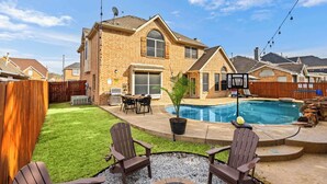 A backyard with a swimming pool, a barbecue area, and a covered patio. - 5-bd Vacation Retreat w Pool & Ping Pong! (Fort Worth)