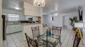 A spacious kitchen with a dining area, a ceiling fan, and a modern chandelier. - Heart of Houston - 3-bd Apartment (Houston)