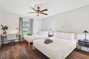 A bedroom with two beds, a desk, a chair, a ceiling fan, and a window with curtains. - 5BR Near At&t Stadium Pool, Hot Tub, Mini Golf (DeSoto)