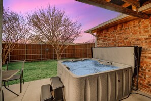 A backyard with a hot tub, a wooden fence, and a brick wall. - Garlands Hidden Gem, 4 Bedrooms, Hot Tub, Patio (Garland)