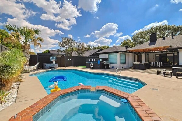A backyard with a swimming pool, a hot tub, and outdoor furniture. - Plano Perfect Getaway - Pool, Hot Tub, BBQ Grill (Plano)