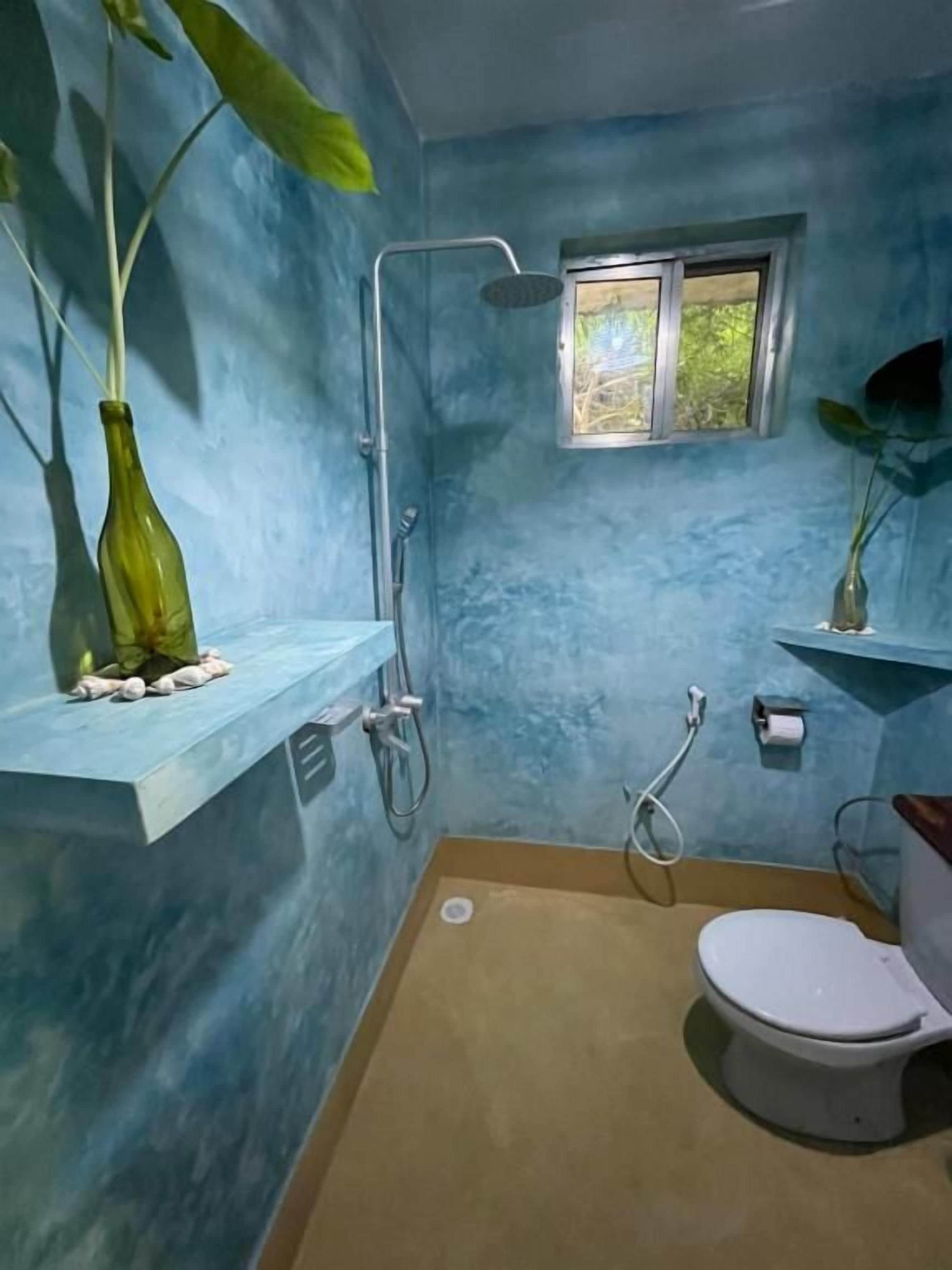 Un baño con ducha, inodoro y ventana.
