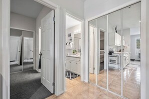A modern interior with a hallway leading to a kitchen and a bedroom.