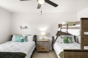 A bedroom with two beds, a ceiling fan, a bedside lamp, and a small nightstand. - Casa de Knight 2.0 (Las Cruces)