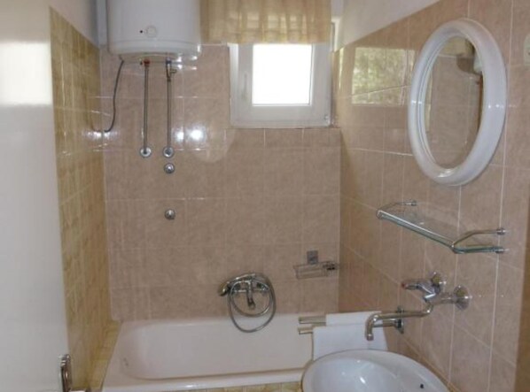 A bathroom with a bathtub, a sink, a toilet, and a window. - Seaview Family Apartment With Grand Terrace (Omis)