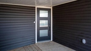 A closed door with a frosted glass panel, a metal handle, and a small window.