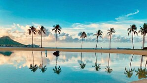 Ein Strand mit Palmen und blauem Himmel.