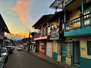 A street with colorful buildings, a visible garage door, and a clear sky. - Room-charming Guest Room With Stunning V (Jardin)