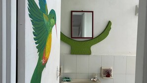 A bathroom with a toilet, sink, mirror, and a bird mural on the wall. - Room-charming Guest Room With Stunning V (Jardin)
