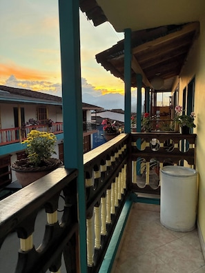 A balcony with potted plants, a railing, and a view of buildings and mountains. - Room-charming Guest Room With Stunning V (Jardin)