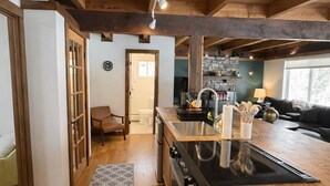 Una cocina amplia con vigas de madera, una isla central y una chimenea de piedra.