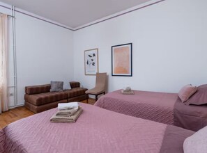 A bedroom with two beds, a sofa, a chair, and two framed pictures on the wall. - Villas Casa Bianca & Maria Residence (Marcana)