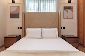A bedroom with a large bed, two nightstands, and artwork on the walls. - 6BR House in Roma Norte with Terrace (Ciudad de mexico)