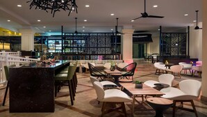 Un espace bar moderne, doté de sièges, d’un comptoir en marbre et d’un éclairage décoratif.