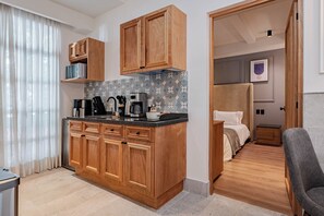 A compact kitchen with wooden cabinets, a countertop, and a coffee machine. - Stylish Roma Norte Loft + Concierge (Ciudad de mexico)