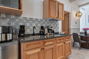A modern kitchen with wooden cabinets, a built-in microwave, and a coffee maker. - Stylish Roma Norte Loft + Concierge (Ciudad de mexico)