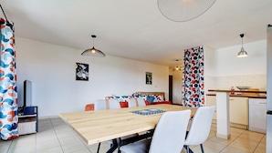 Eine moderne Küche mit Essbereich, einer Couch und einem Fernseher.