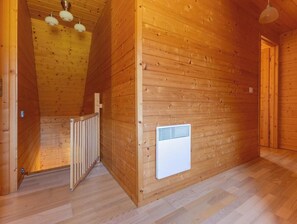 A wooden interior with a sloped ceiling, a radiator, and a door. - Chalet du moulin - GELLES (GELLES)
