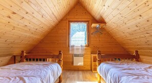 A wooden cabin with two beds, a window with lace curtains, and a hanging coat rack. - Chalet du moulin - GELLES (GELLES)