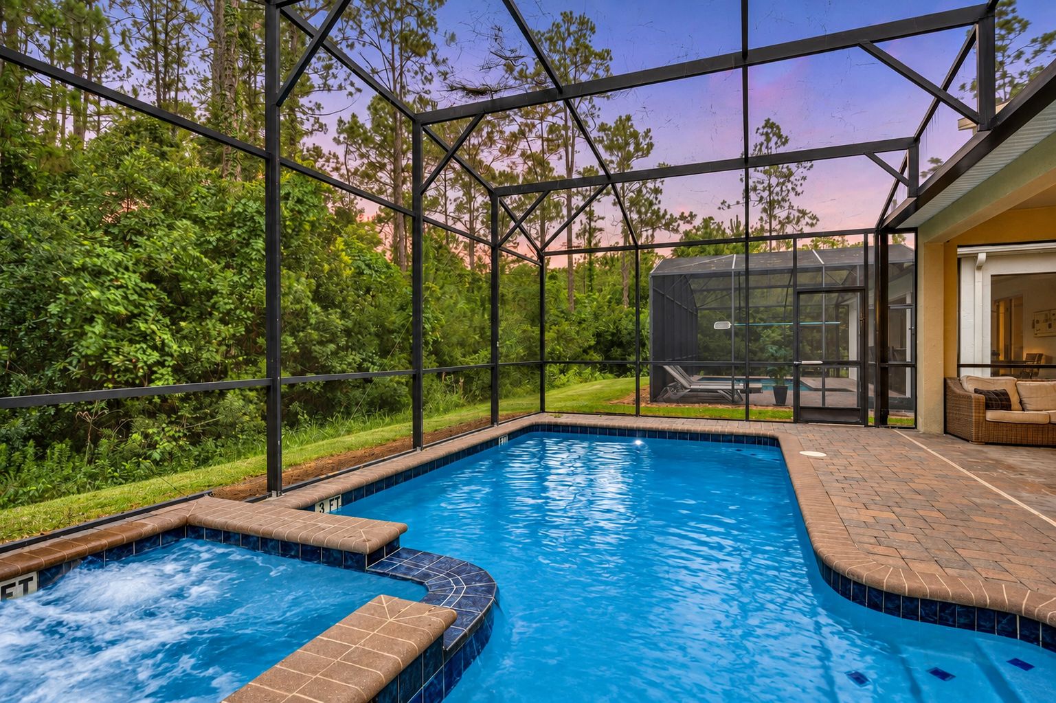 A swimming pool with a glass enclosure, surrounded by greenery and a covered seating area.