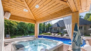 A hot tub under a wooden pergola with a pool in the background. - Luxury Private Estate Retreat. 
Pool • Hot Tub • Gym • Pool Table (Halton Hills)