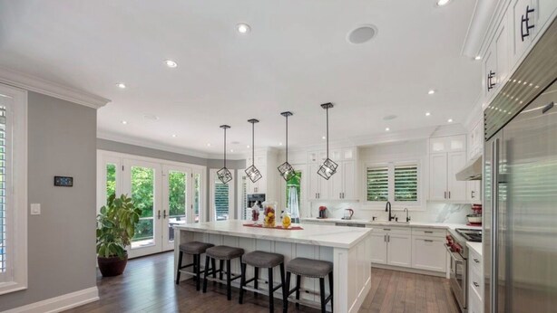 A modern kitchen with a large island, bar stools, pendant lighting, and a refrigerator. - Luxury Private Estate Retreat. 
Pool • Hot Tub • Gym • Pool Table (Halton Hills)