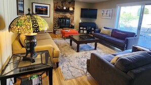 A living room with a fireplace, a television, and a large window.