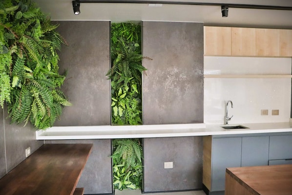 A kitchen with a built-in vertical garden, a modern sink, and a wooden countertop. - Central Apartment Near Metro & Iconic Sights w/ (Santiago)