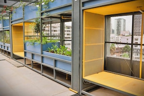 A modern building with blue and yellow structural elements, metal mesh windows, and indoor plants. - Central Apartment Near Metro & Iconic Sights w/ (Santiago)