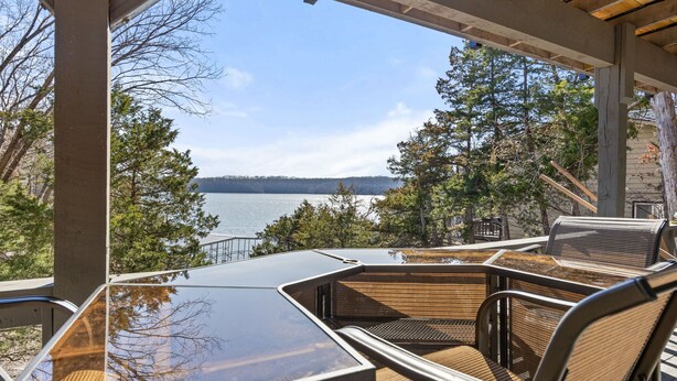 An outdoor seating area with a view of a lake and trees. - Lakefront home in Osage Beach - Newly Renovated (Osage Beach)