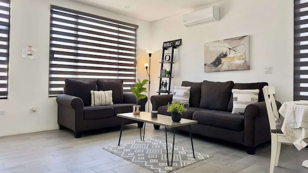 Ein modernes Wohnzimmer mit zwei Sofas, einem Couchtisch und einem Bild an der Wand.
