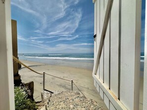 A beach view from a building with a stone staircase leading to a sandy area. - Little Pearl Sea View Studio (San Antonio del Mar)