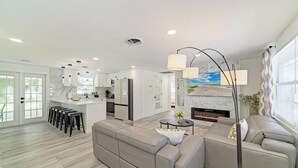 Een moderne woonkamer met een bank, een salontafel en een open haard.