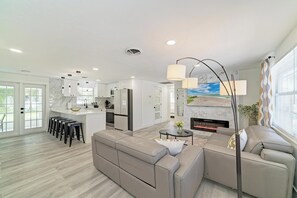 Ein modernes Wohnzimmer mit einer Couch, einem Couchtisch und einem Kamin.