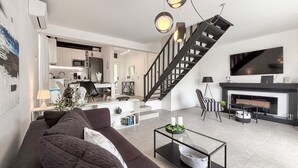 Ein modernes Wohnzimmer mit einer Couch, einem Couchtisch, einem Kamin und einer Treppe.