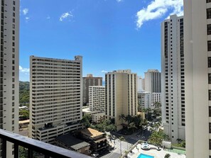 Ein hoch aufragender Gebäudekomplex mit mehreren Stockwerken, blauem Himmel und einem Schwimmbecken im Vordergrund.