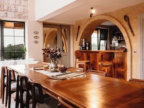 A dining area with a long wooden table, chairs, and a vase with flowers. - Salanush House Of Cappadocia (Nevşehir)