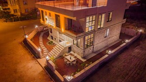 A multi-story building with a prominent entrance and a patio area with outdoor seating. - Salanush House Of Cappadocia (Nevşehir)