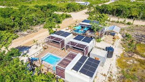Et resort med flere solcelledrevne bygninger, en swimmingpool og havudsigt.