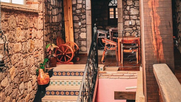 A rustic interior with a stone wall, wooden staircase, and a glass ceiling. - Cozy suite in downtown Morelia (Morelia)