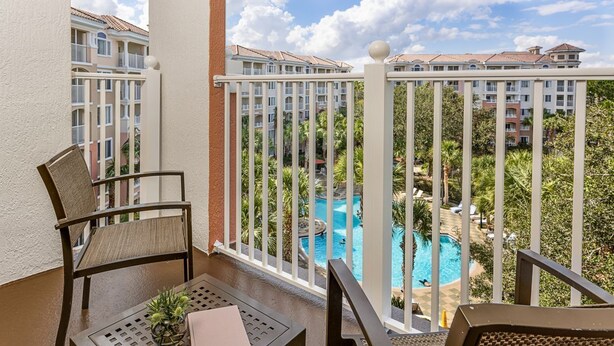 A balcony with a view of a swimming pool and adjacent buildings. - ORLANDO RESORT VILLA 2BR MARRIOTT GRANDE VISTA SLEEPS 8 (Orlando)