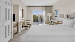 A hotel room with a bed, a desk, a chair, a TV, a balcony with curtains, and a window with a view. - ORLANDO RESORT VILLA 2BR MARRIOTT GRANDE VISTA SLEEPS 8 (Orlando)
