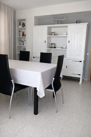 A dining area with a white table, black chairs, a white cabinet with shelves, and a number '22' sign. - Fantastic accommodation in first line of Levante beach, BENIDORM. (Benidorm)