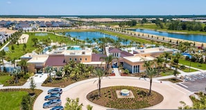 Ein Resort mit Hauptgebäude, einer Rundfahrt, einem Parkplatz und einem See.